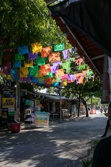 A man standing under a colorfully decorated umbrella