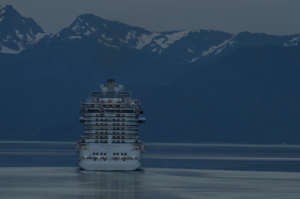Cruise ship sailing past Alaskan glaciers and mountains