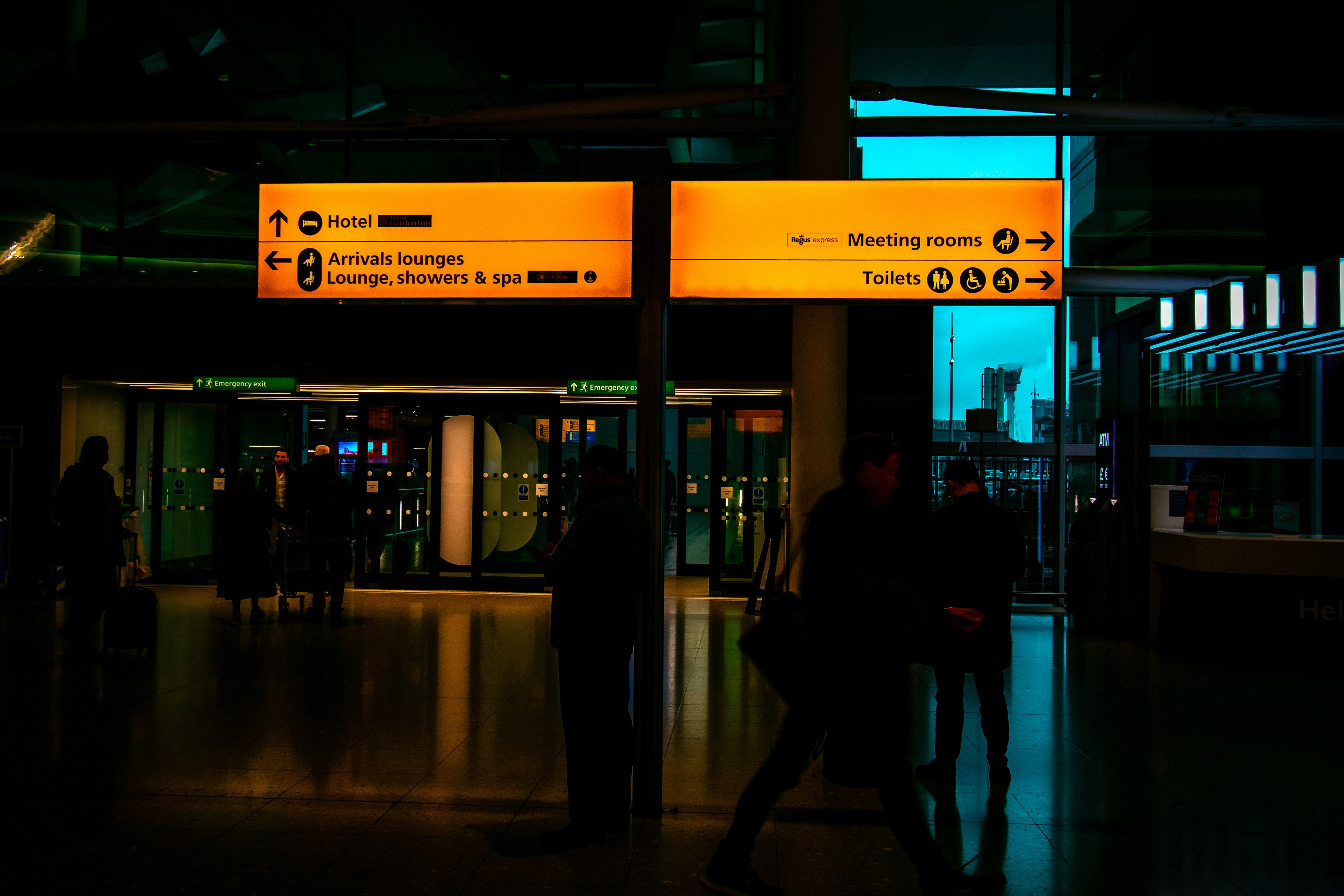 A group of people walking through a terminal at night, Where to go from here?
