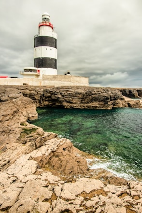 A lighthouse sitting on top of a cliff next to the ocean