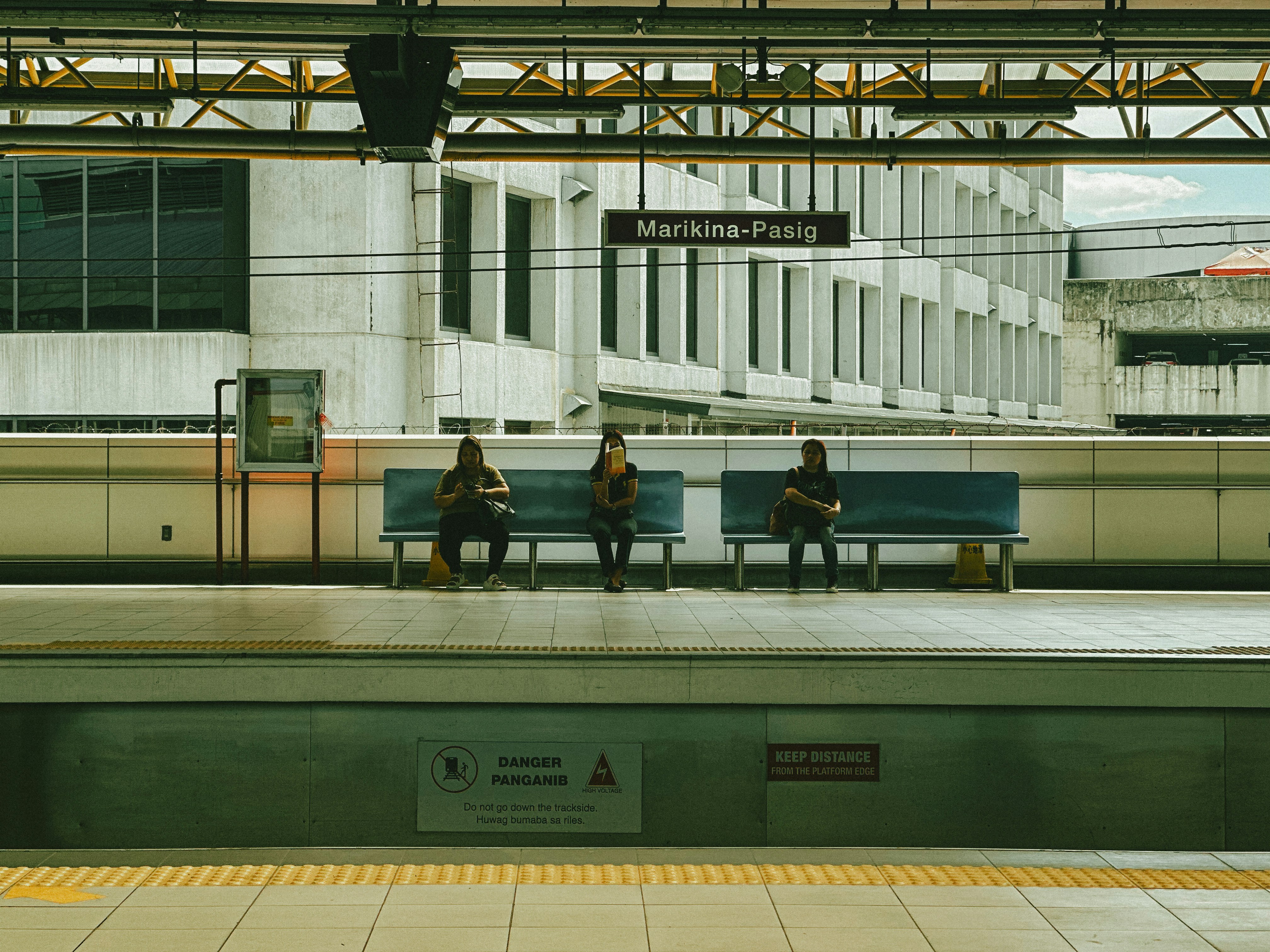 A group of people sitting on a bench in a train station