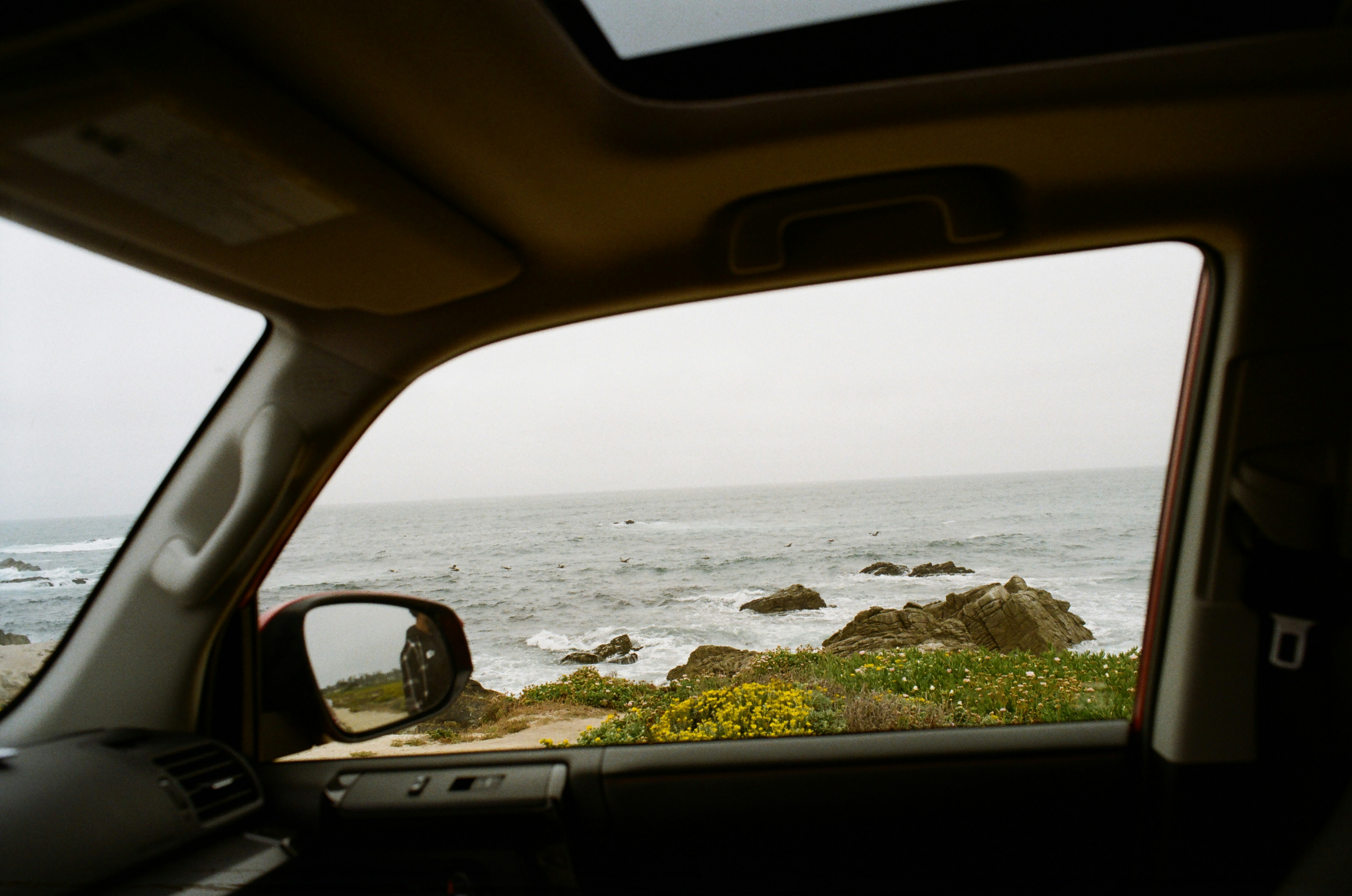 A view of the ocean from inside a car
