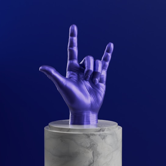 A purple hand sticking out of a marble container