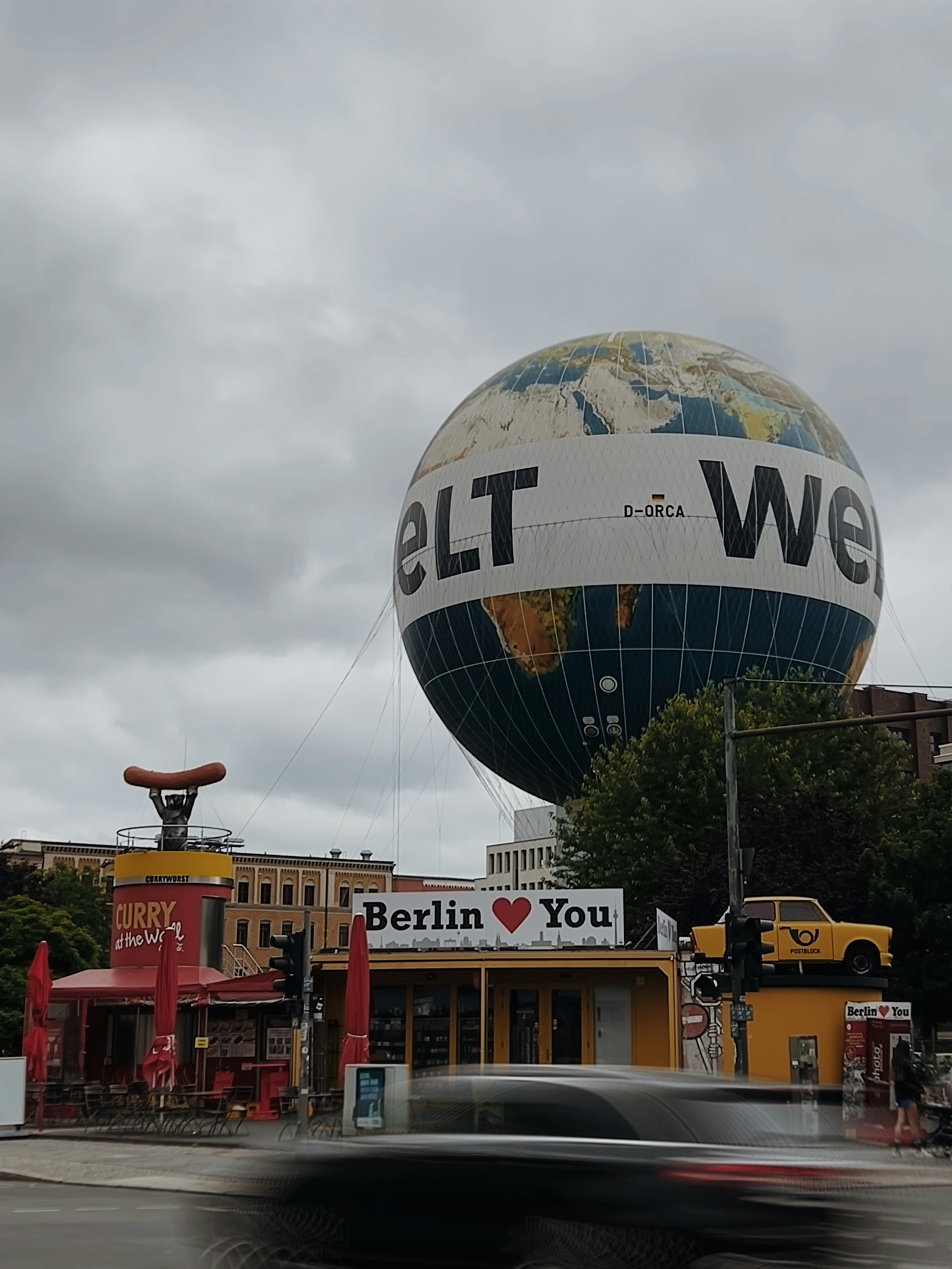 A car driving past a large globe on top of a building