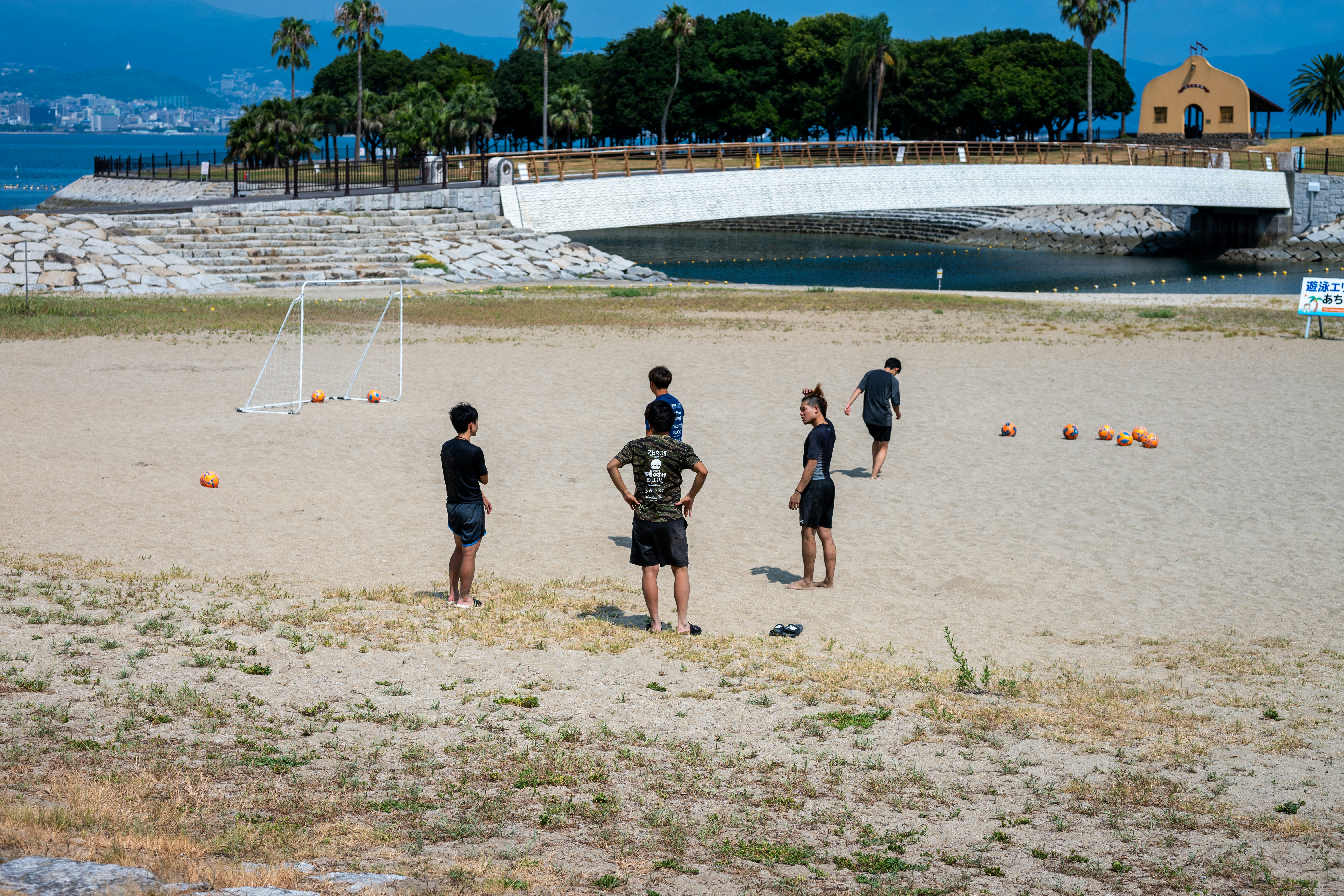 A group of people standing on top of a sandy beach