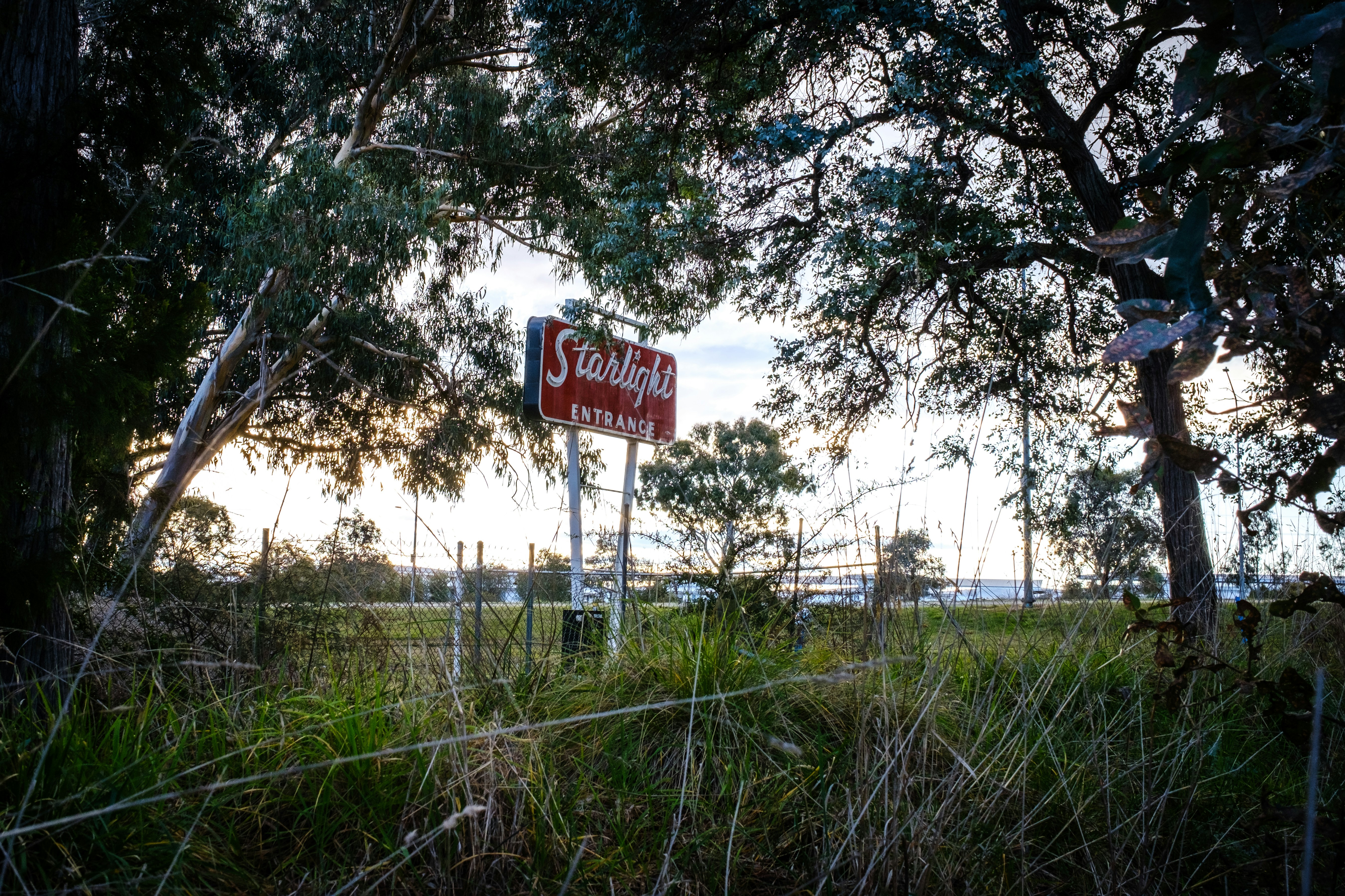 A red and white street sign sitting on the side of a road