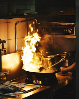 A large pot on a stove with flames in it