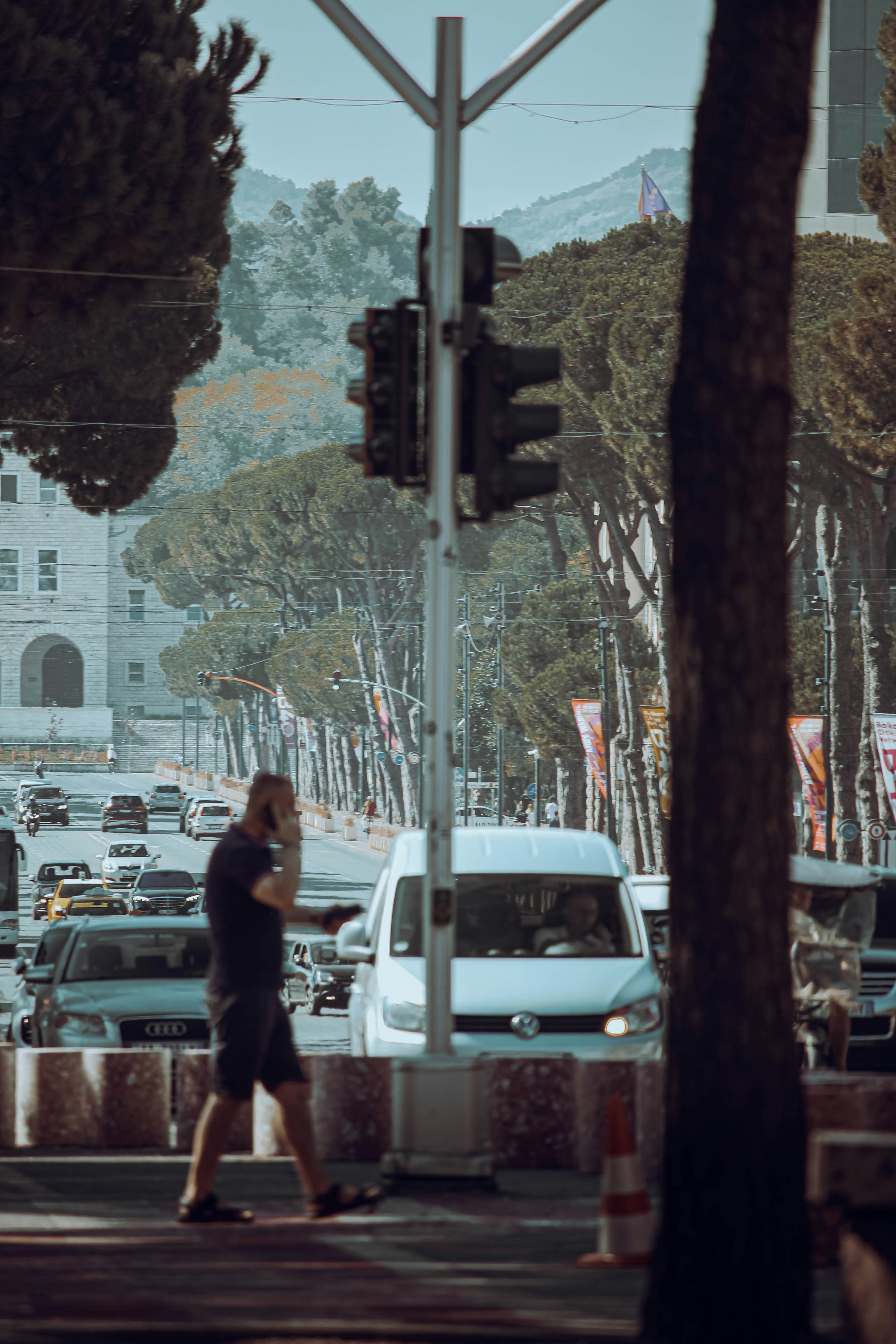 A man walking across a street next to a traffic light