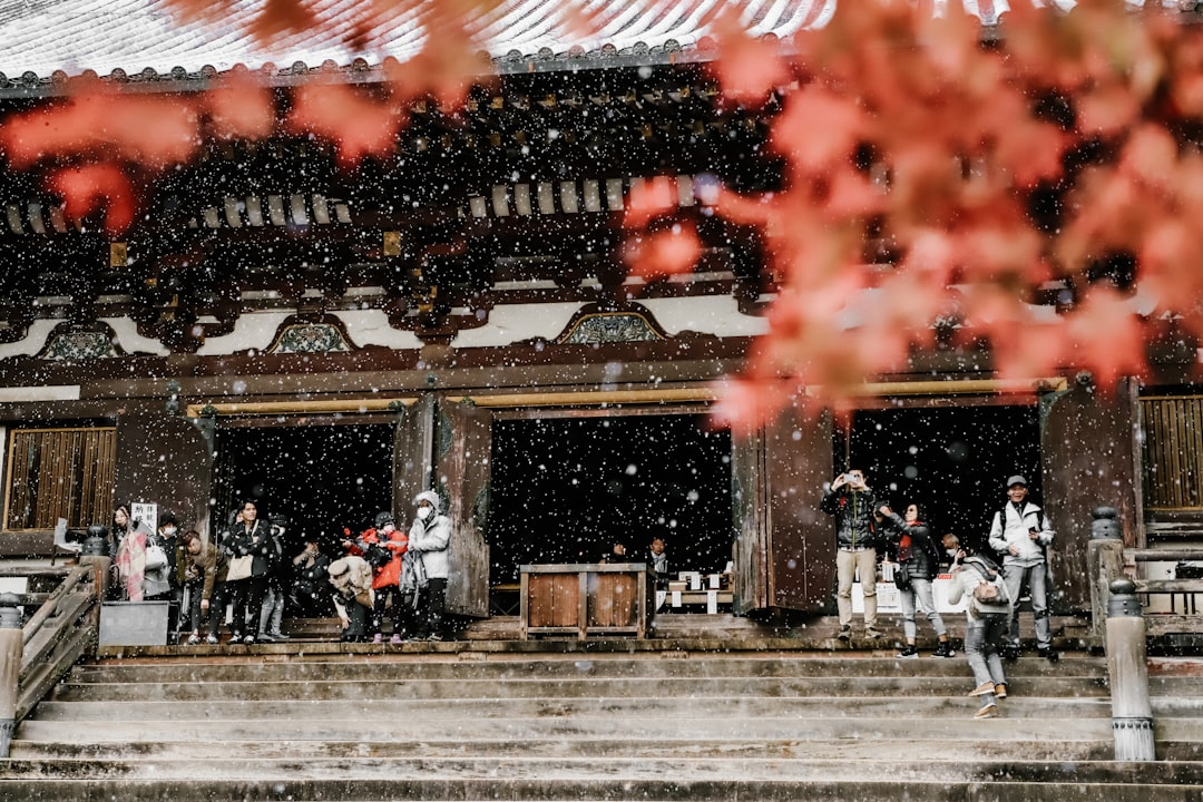 A group of people standing outside of a building in the snow,