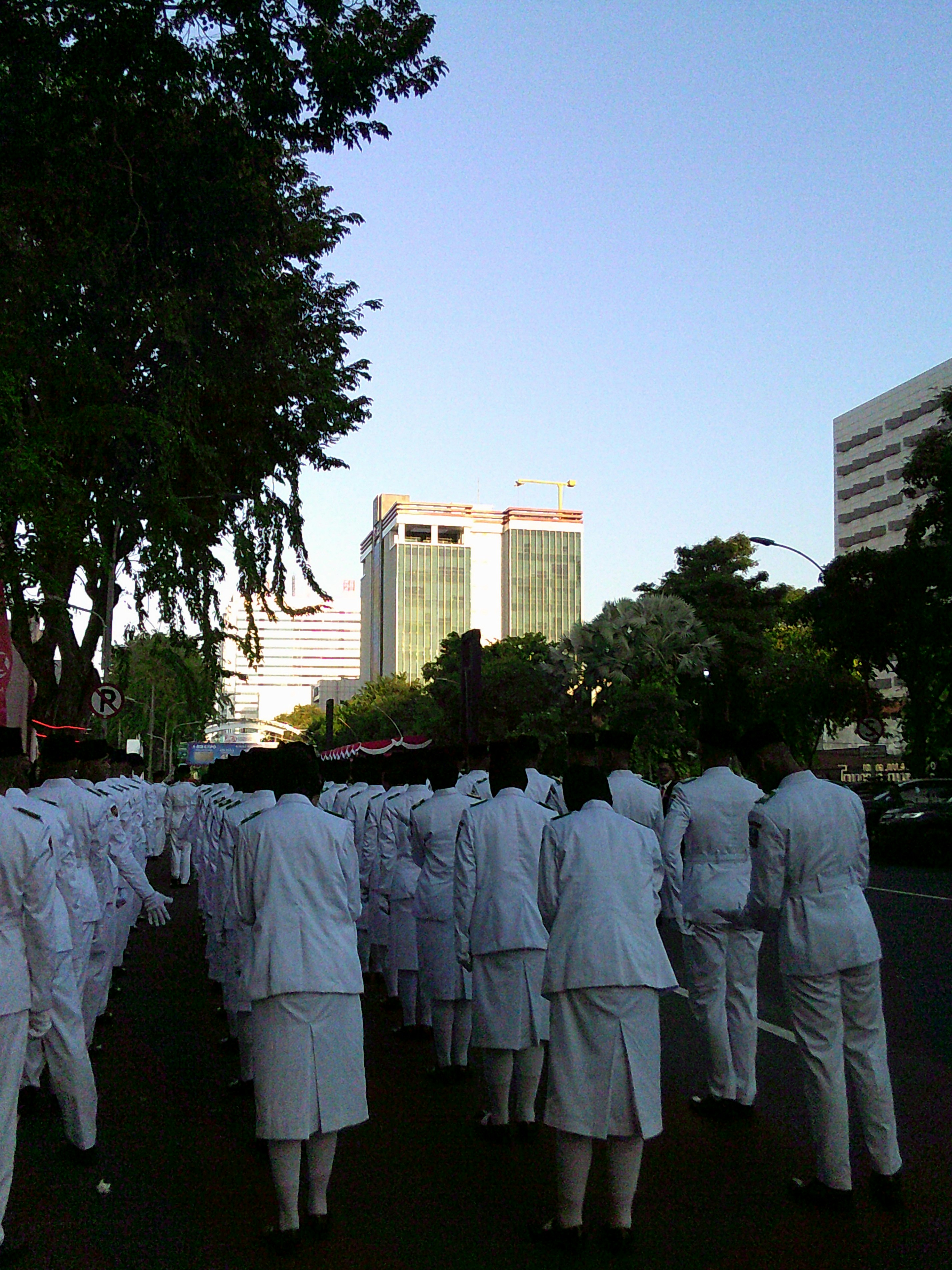 A group of people dressed in white walking down a street