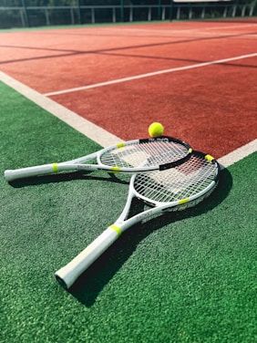 A tennis racket and two tennis balls on a tennis court