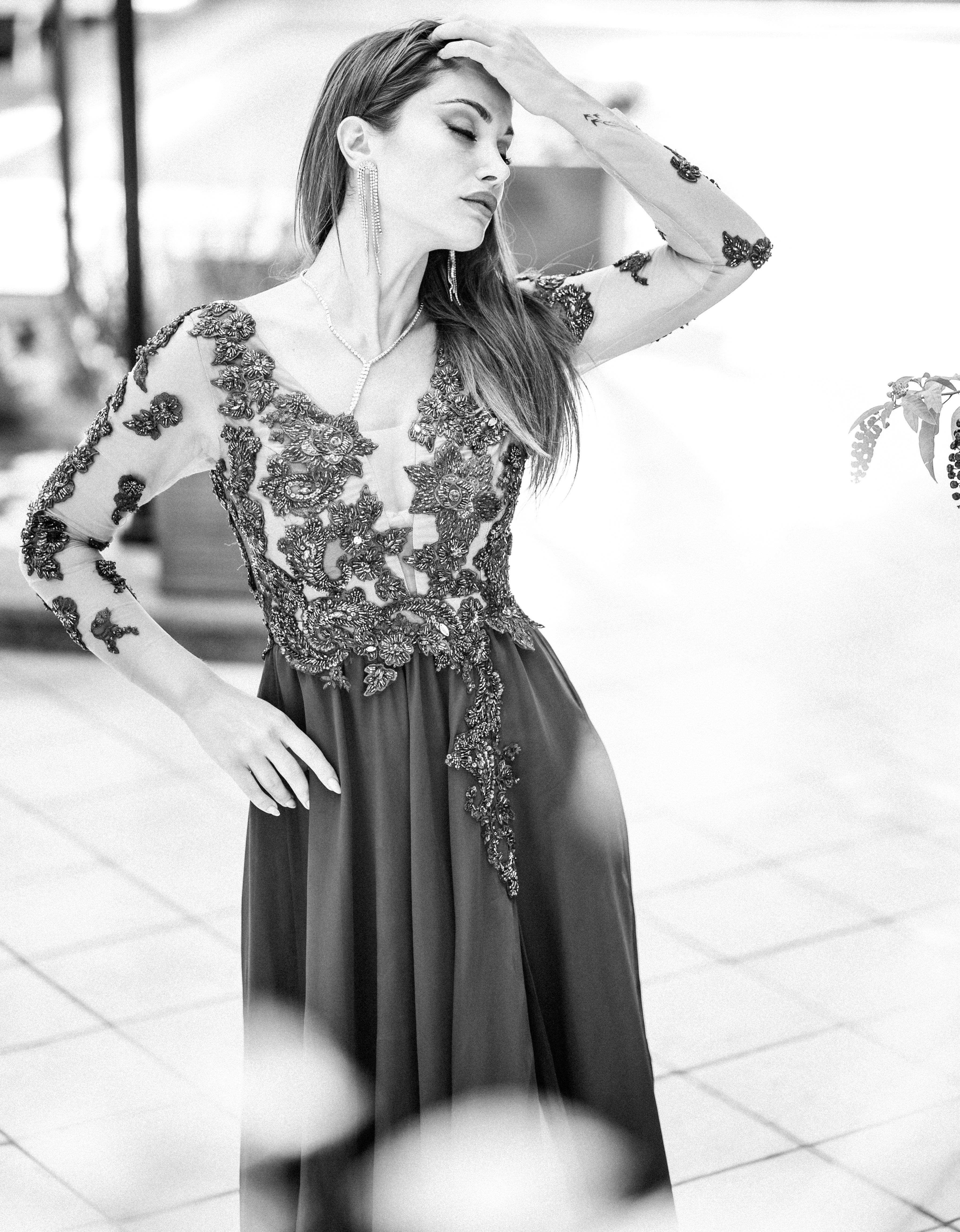 A woman in a long dress standing on a sidewalk