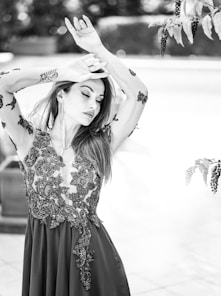 A woman in a long dress is holding her hands up