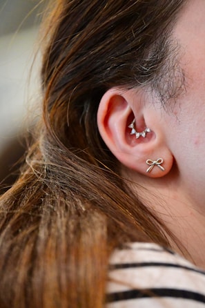 A close up of a person wearing a pair of ear piercings