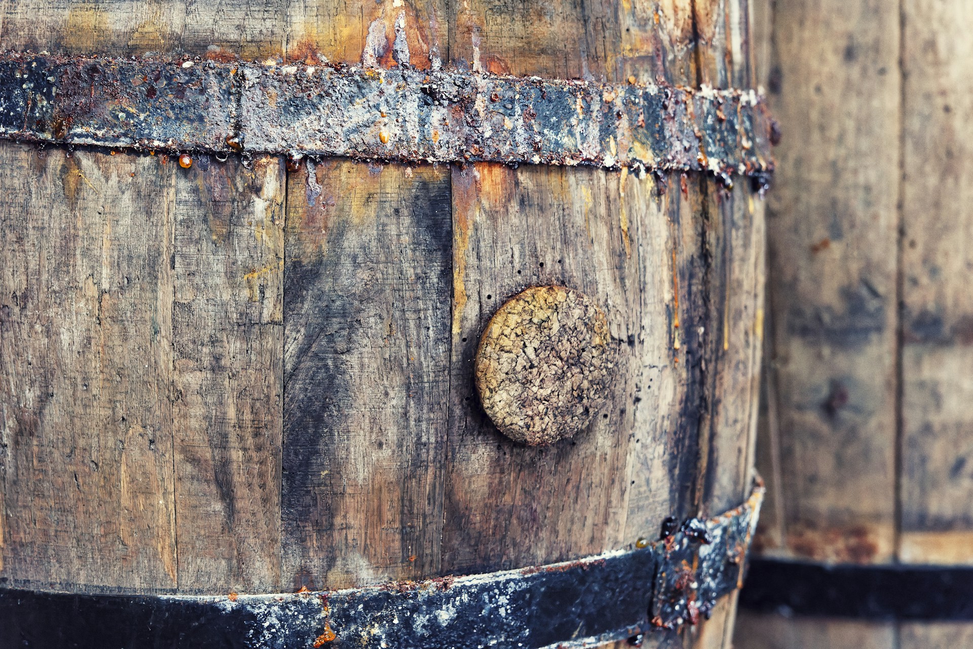 A close up of a wooden barrel with rust on it