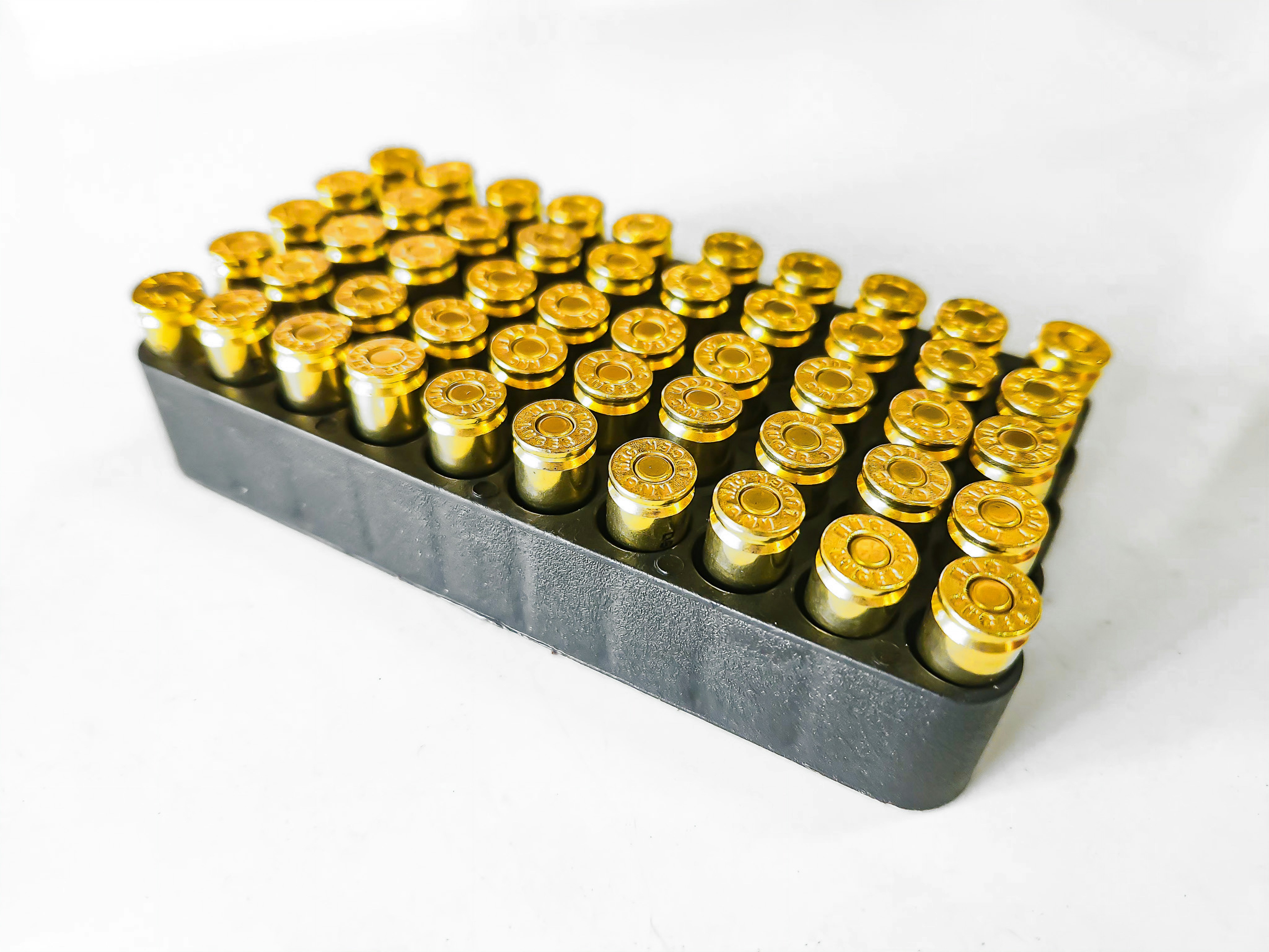 A bunch of gold bullet shells sitting on a white surface