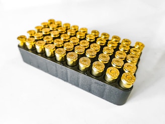 A bunch of gold bullet shells sitting on a white surface