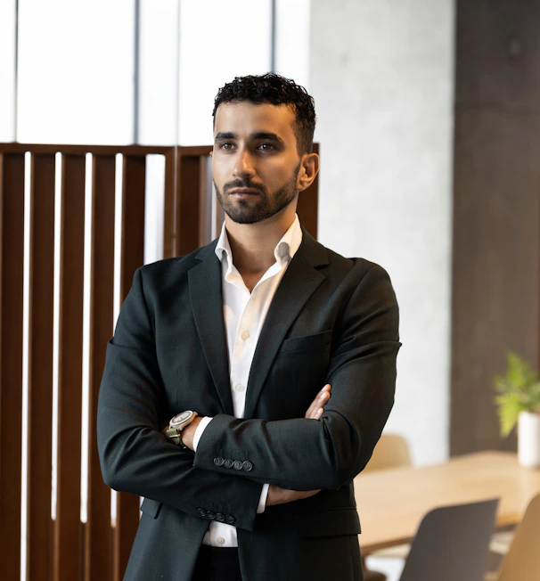 A man in a suit standing with his arms crossed