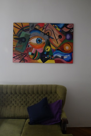 A living room with a couch and a painting on the wall
