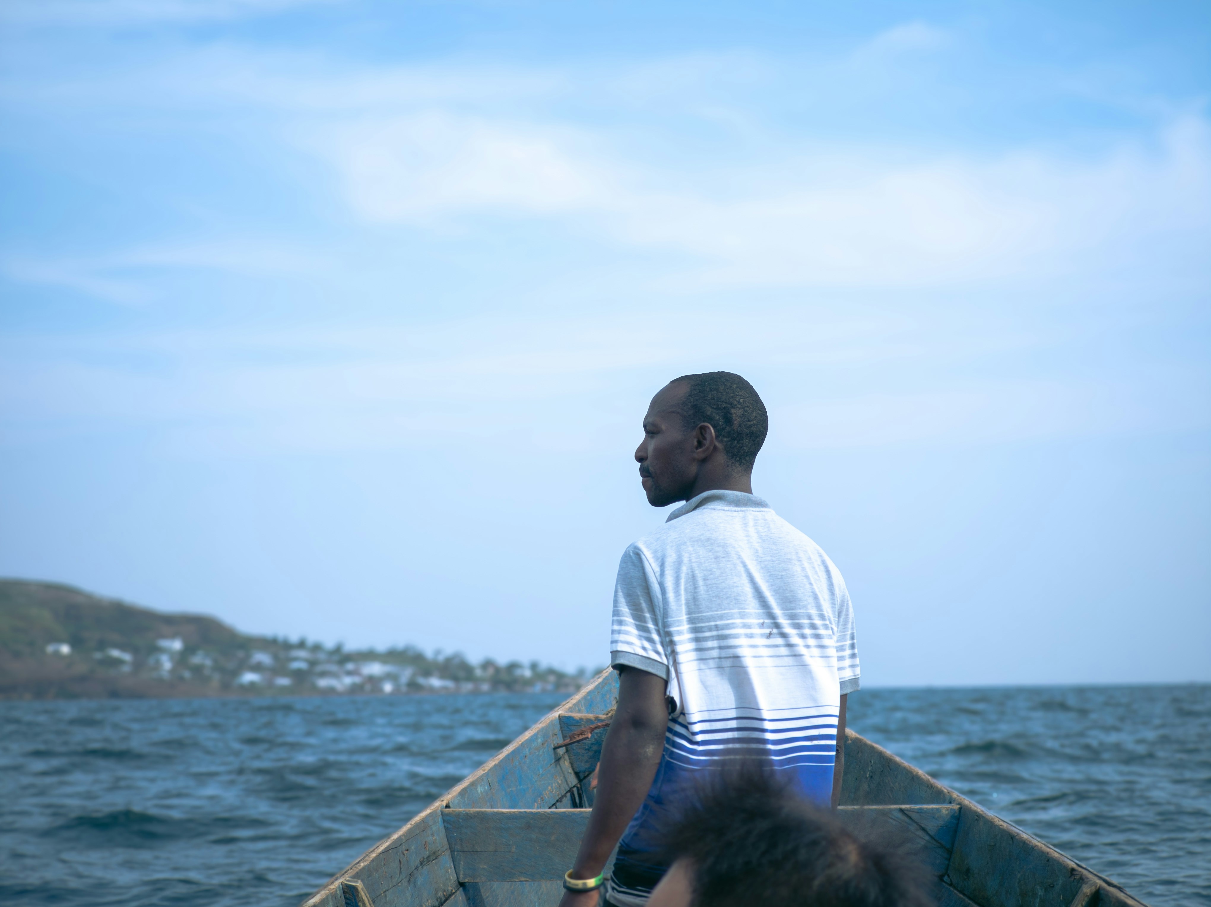 A man standing in a boat on the water photo – Free Man Image on Unsplash