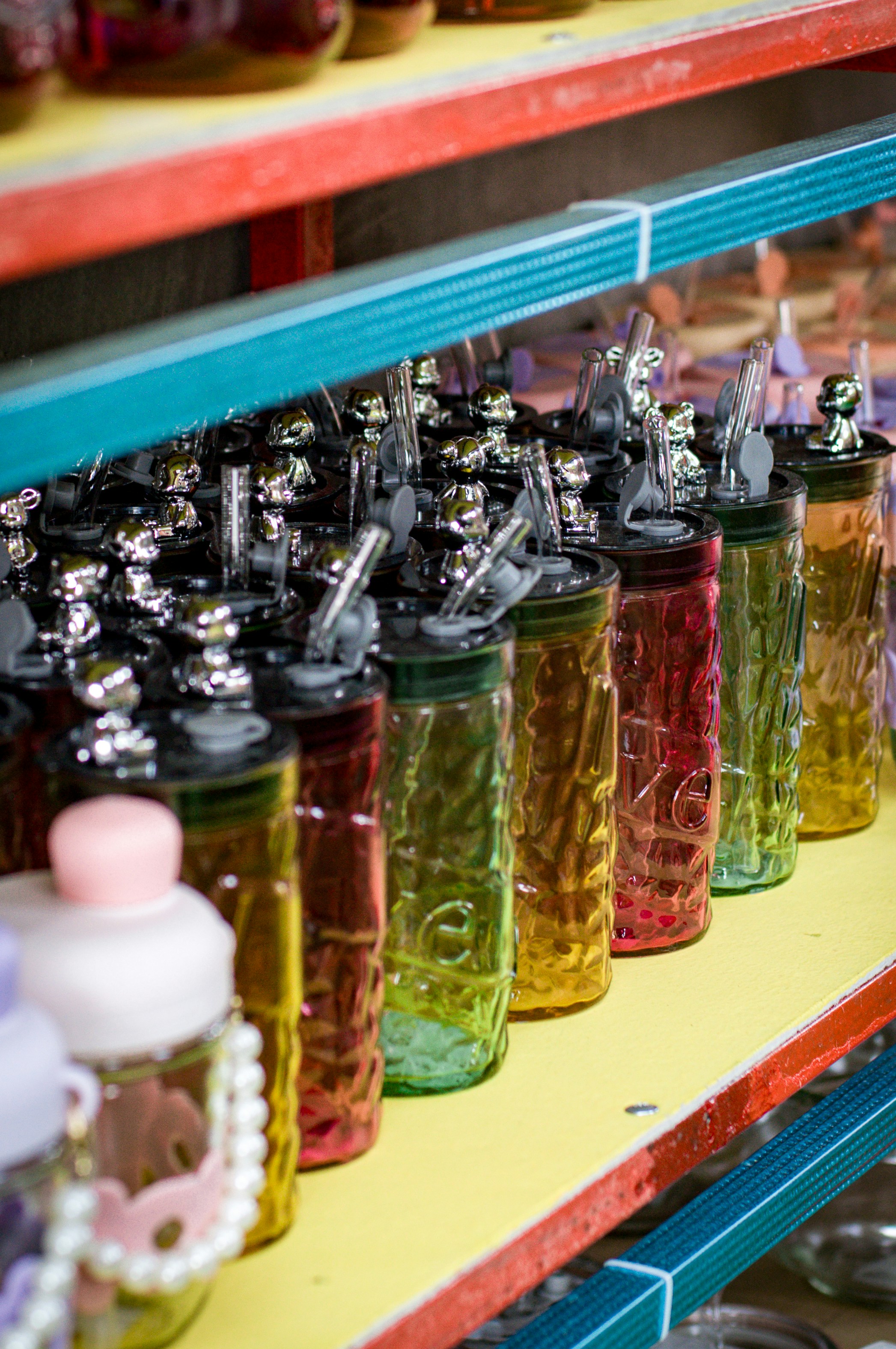 A shelf filled with lots of different colored bottles