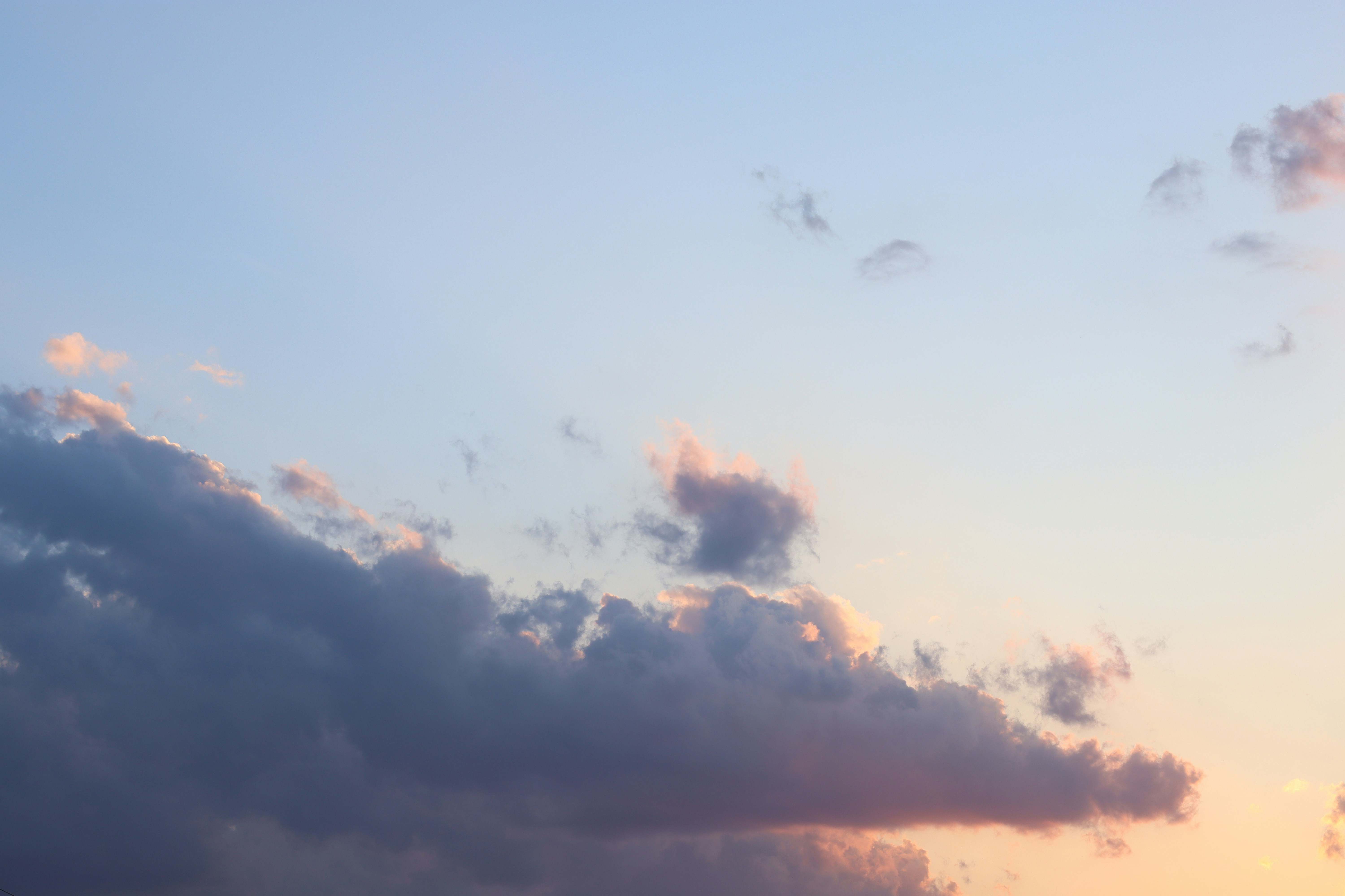 A plane flying in the sky at sunset