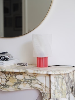 A table with a mirror and a lamp on top of it