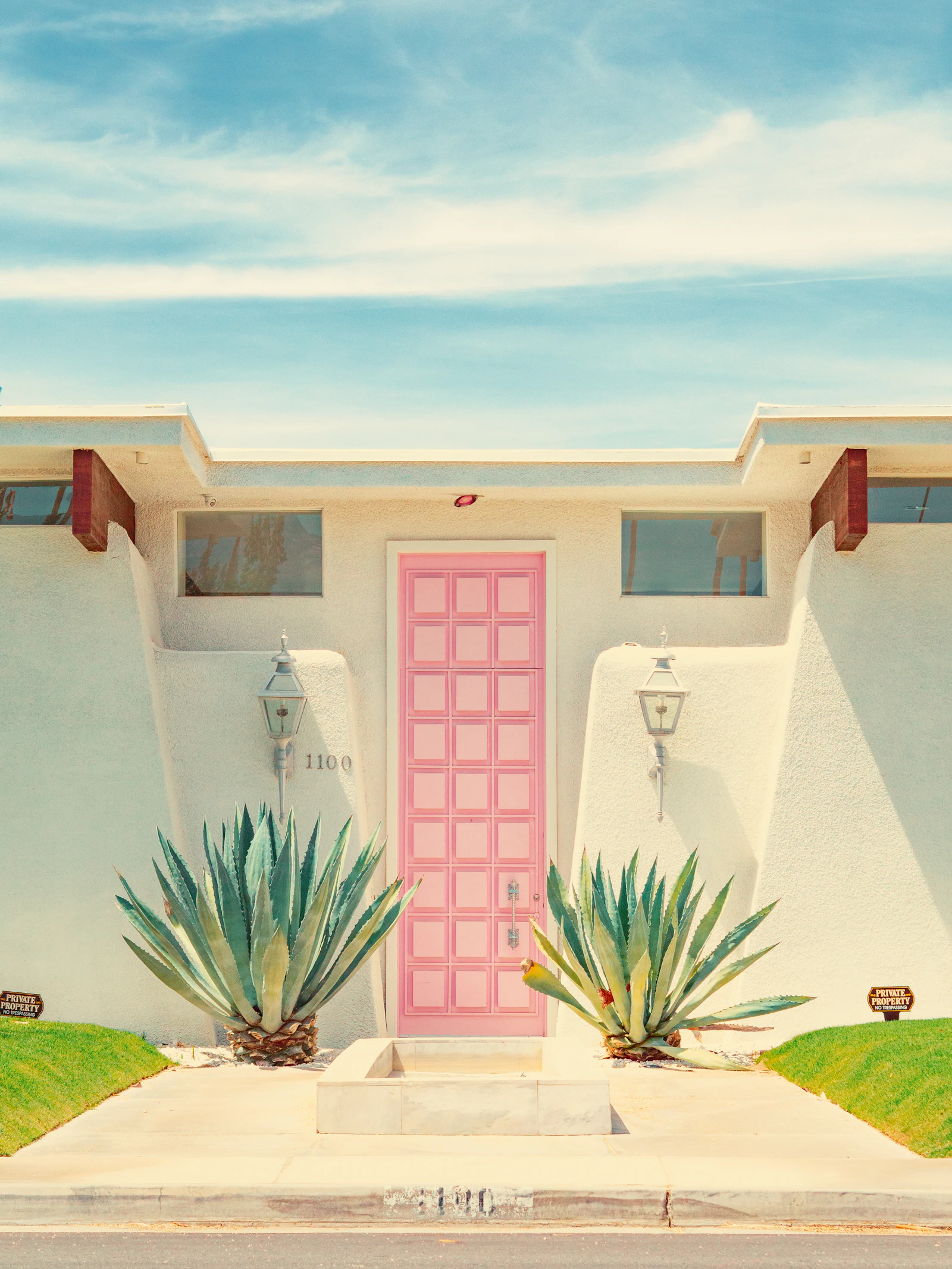 A pink front door on a white mid-century house