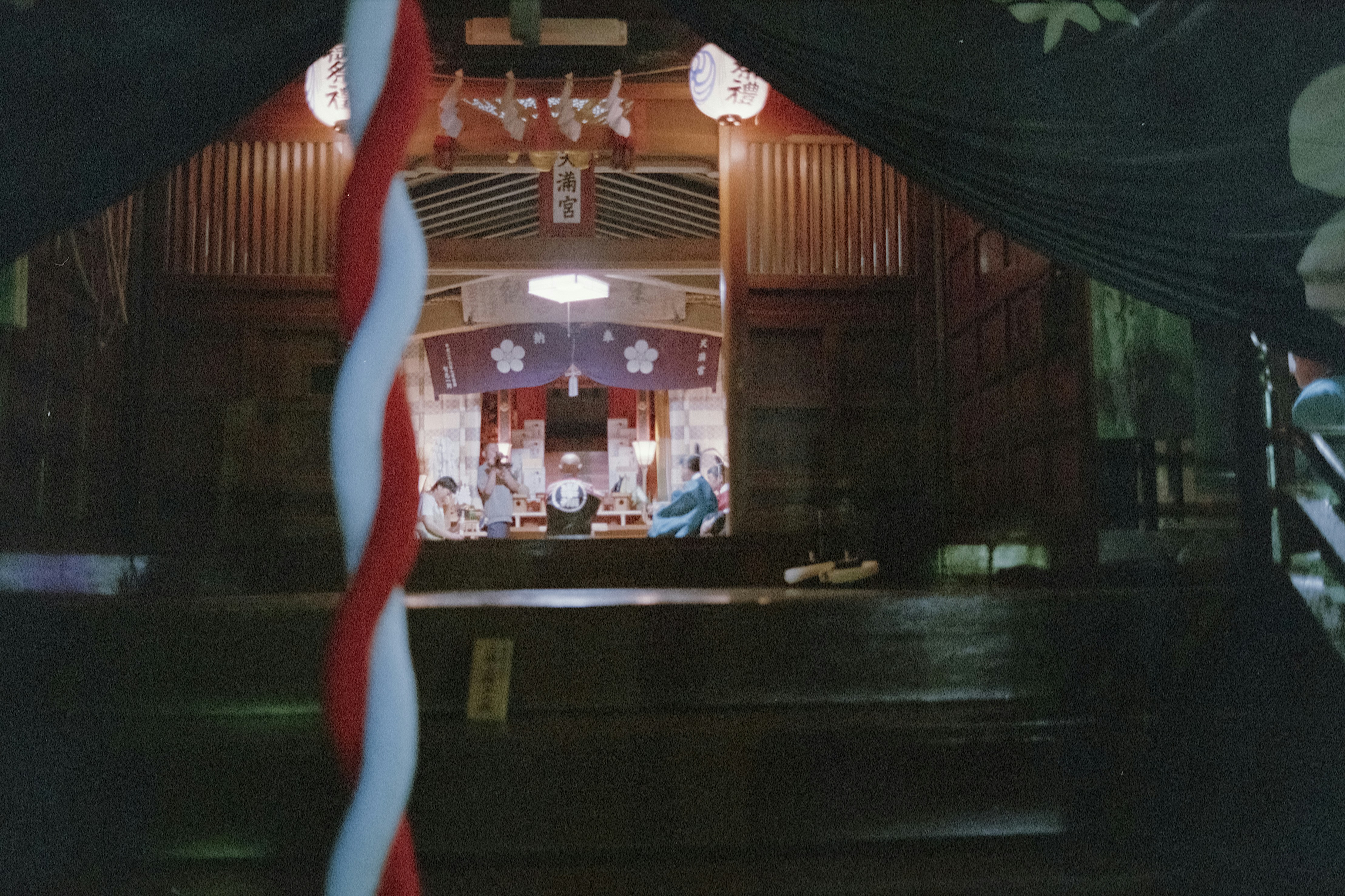 Traditional Japanese restaurant entrance with blue noren curtains and red akachōchin lanterns