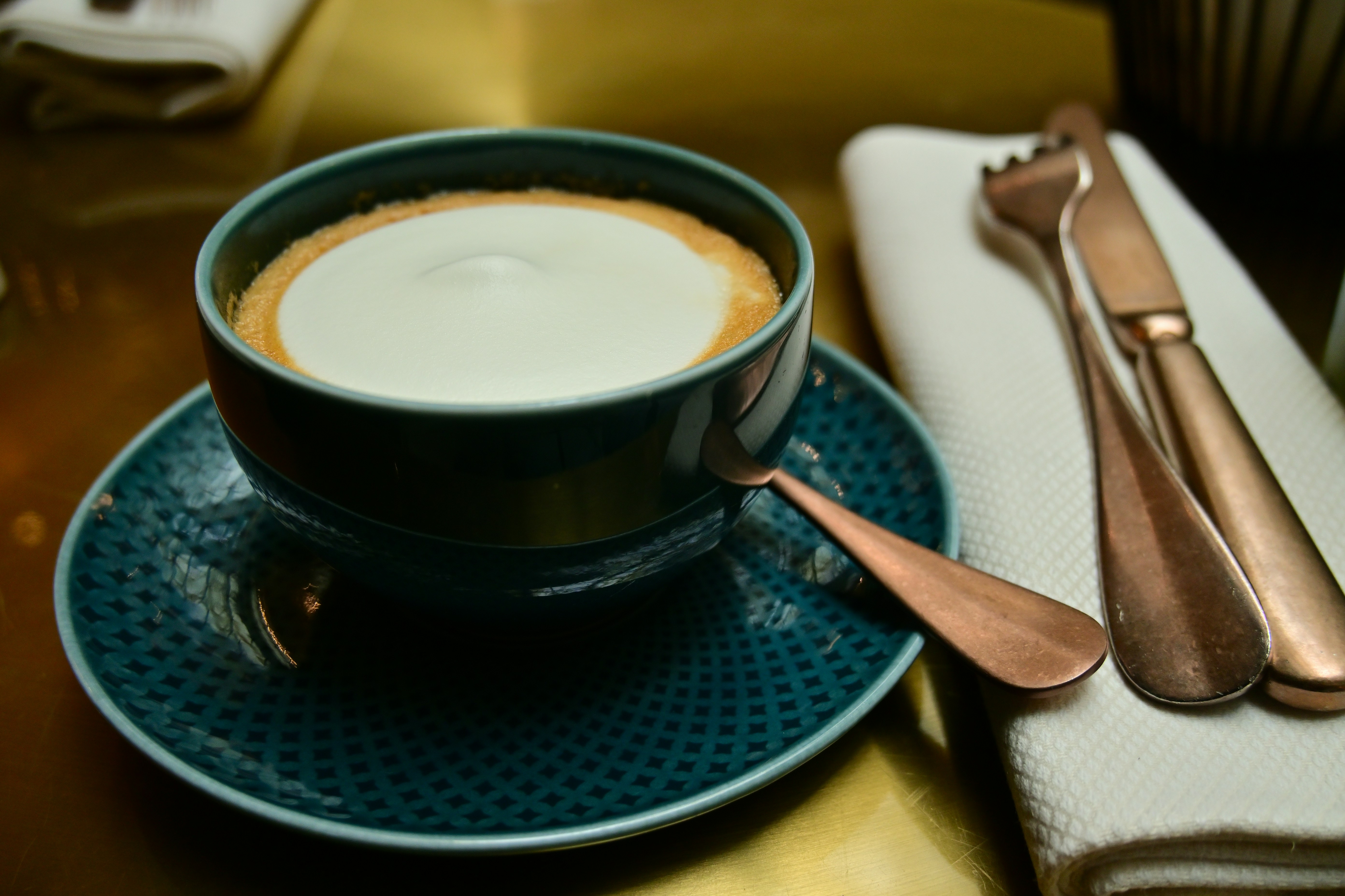 A cup of coffee sitting on top of a blue plate