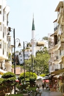 A city street with a tall white building in the background
