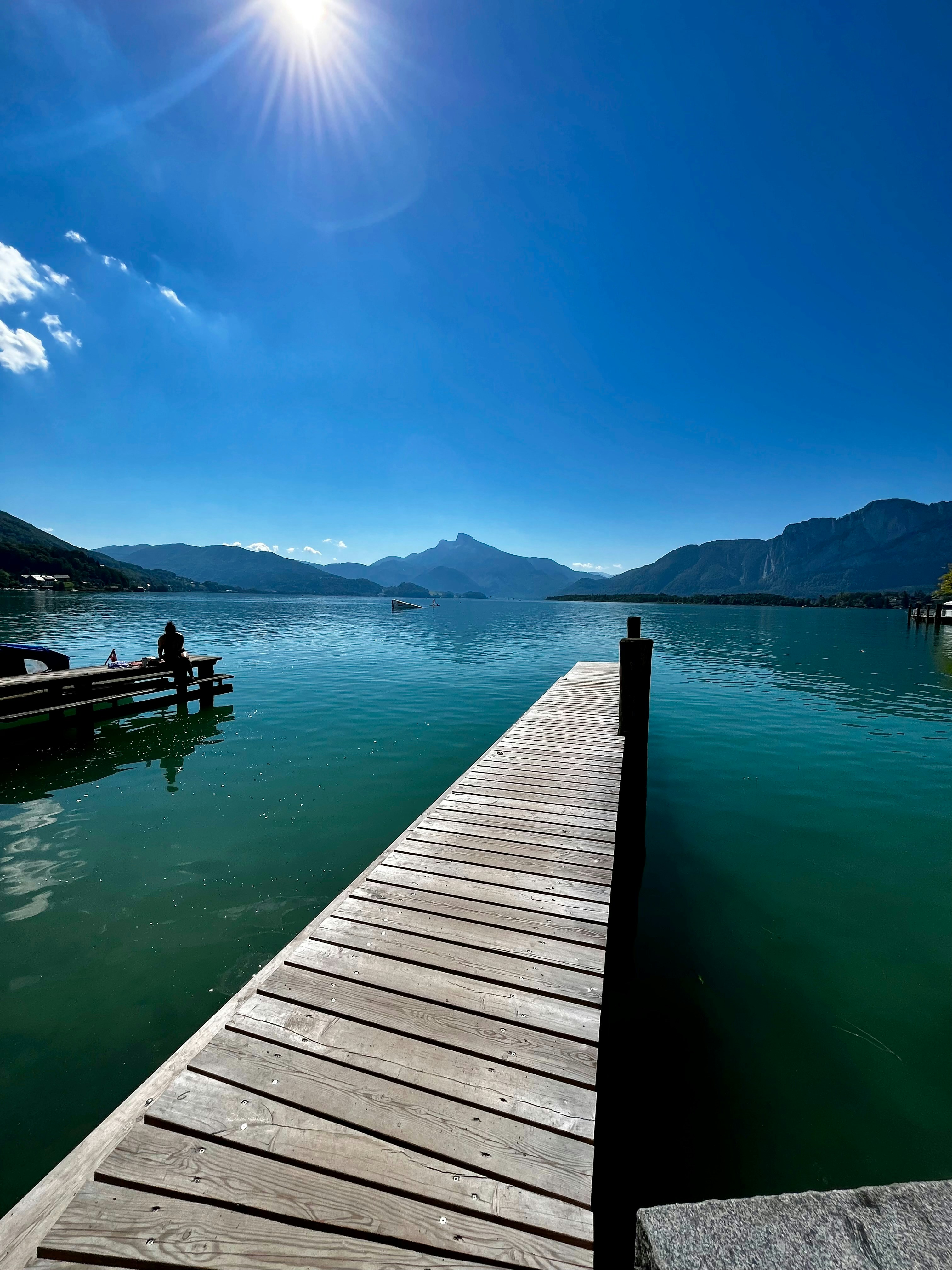 A dock on a body of water with mountains in the background
