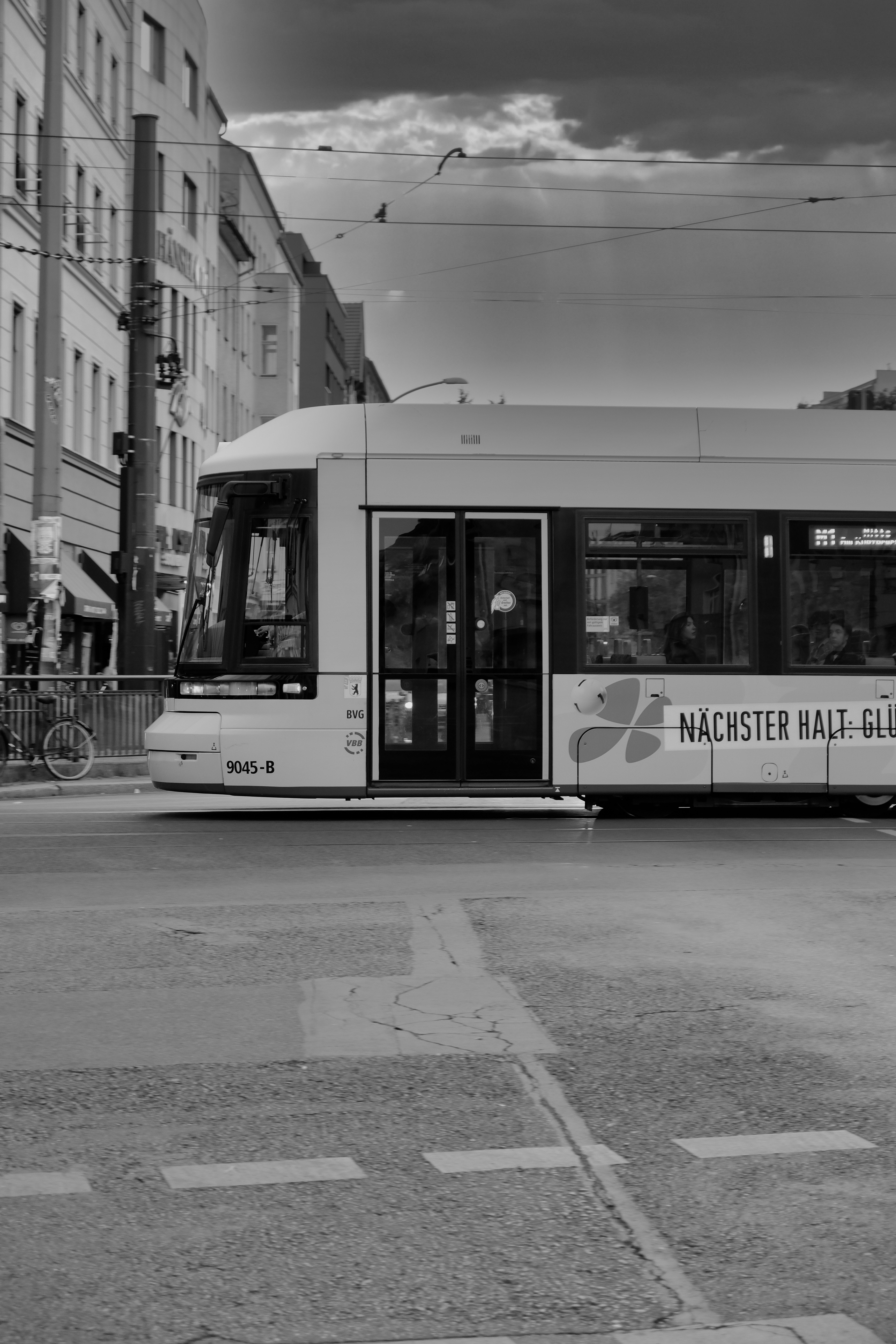 A black and white photo of a bus on a street - a-black-and-white-photo-of-a-bus-on-a-street-nioIpPoK9PE