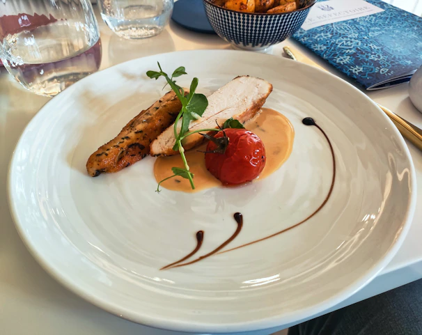 A white plate topped with meat and vegetables