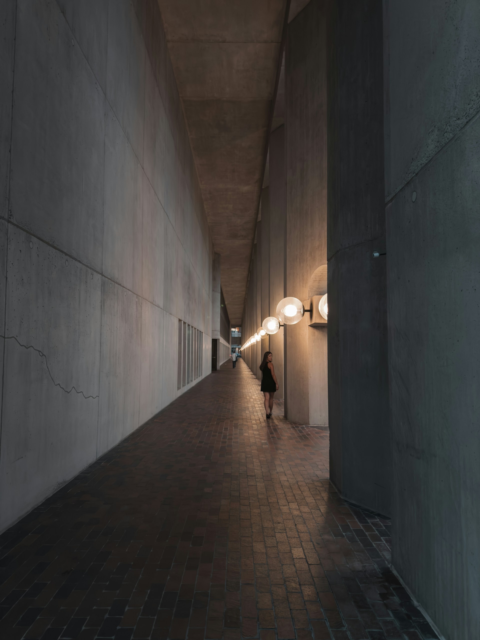 A person walking down a long hallway in a building