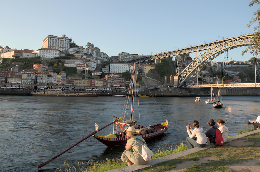 A group of people sitting on the side of a river,
