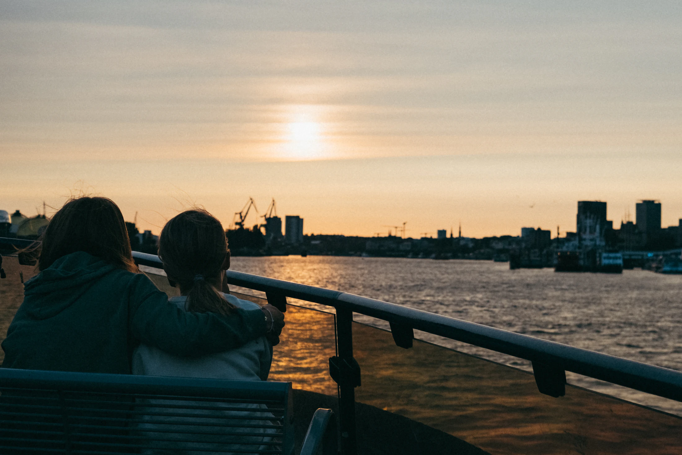 Two people sitting together at sunset
