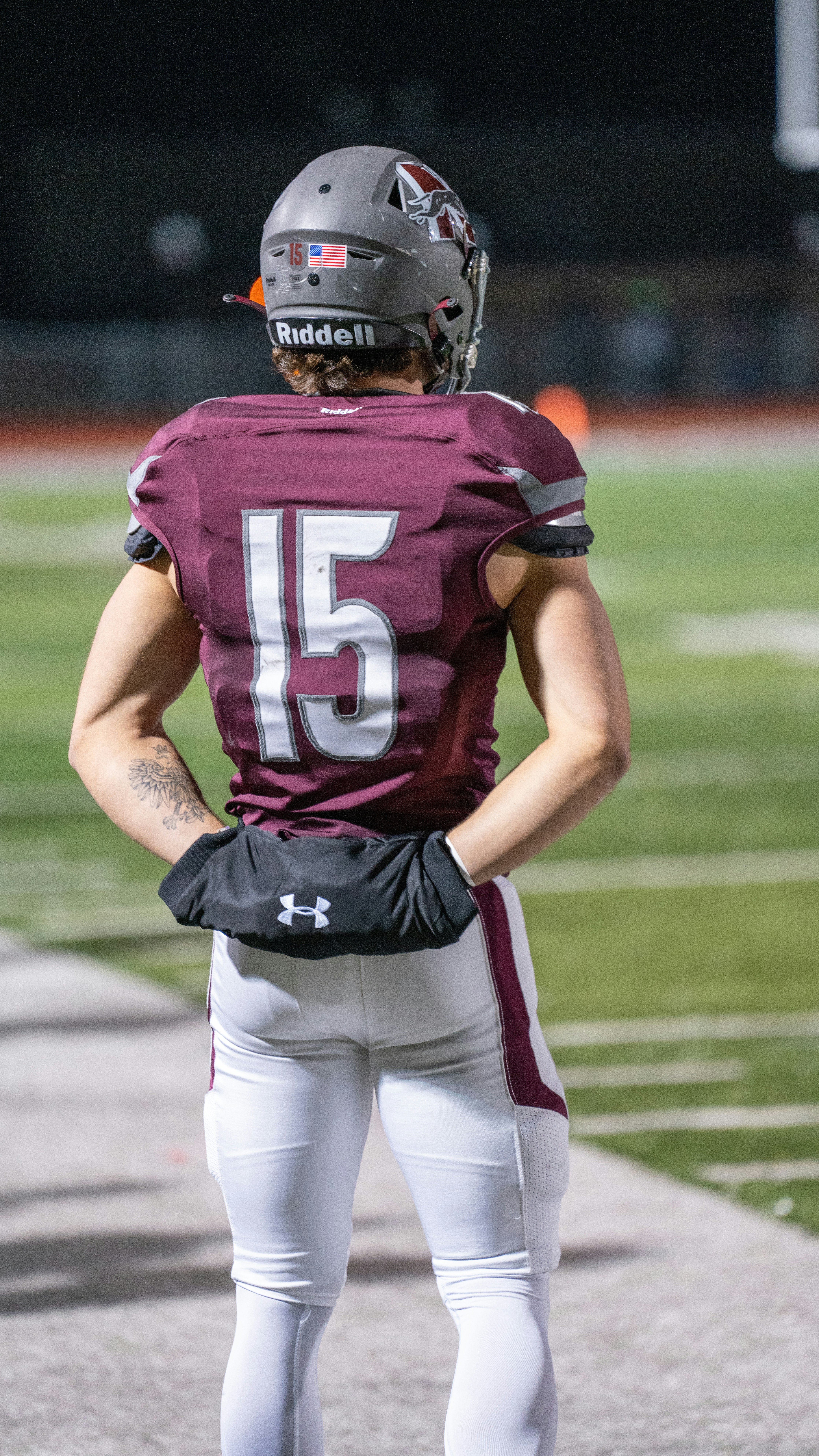 A football player standing on a field with his back to the camera
