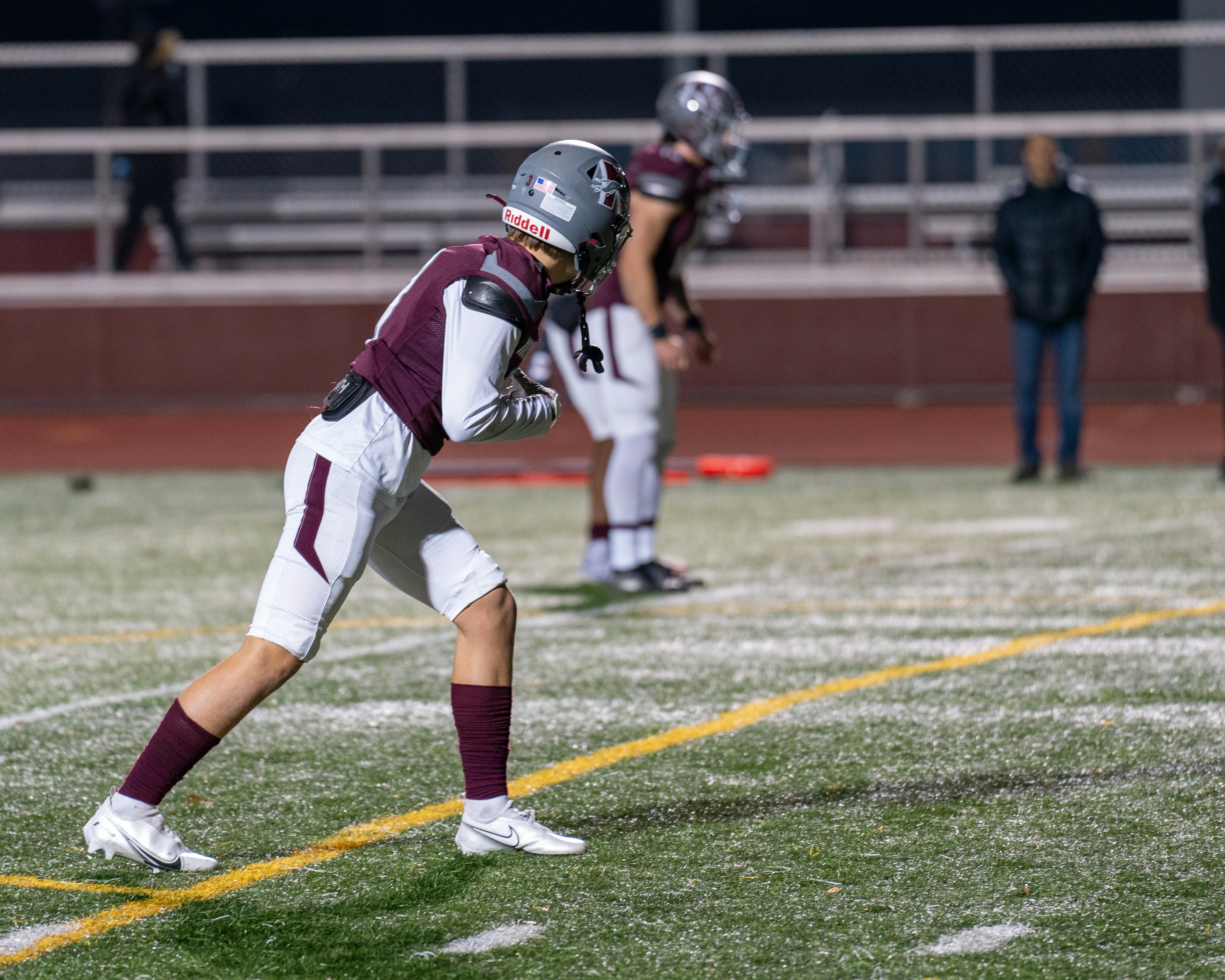 A football player standing on a field holding a ball