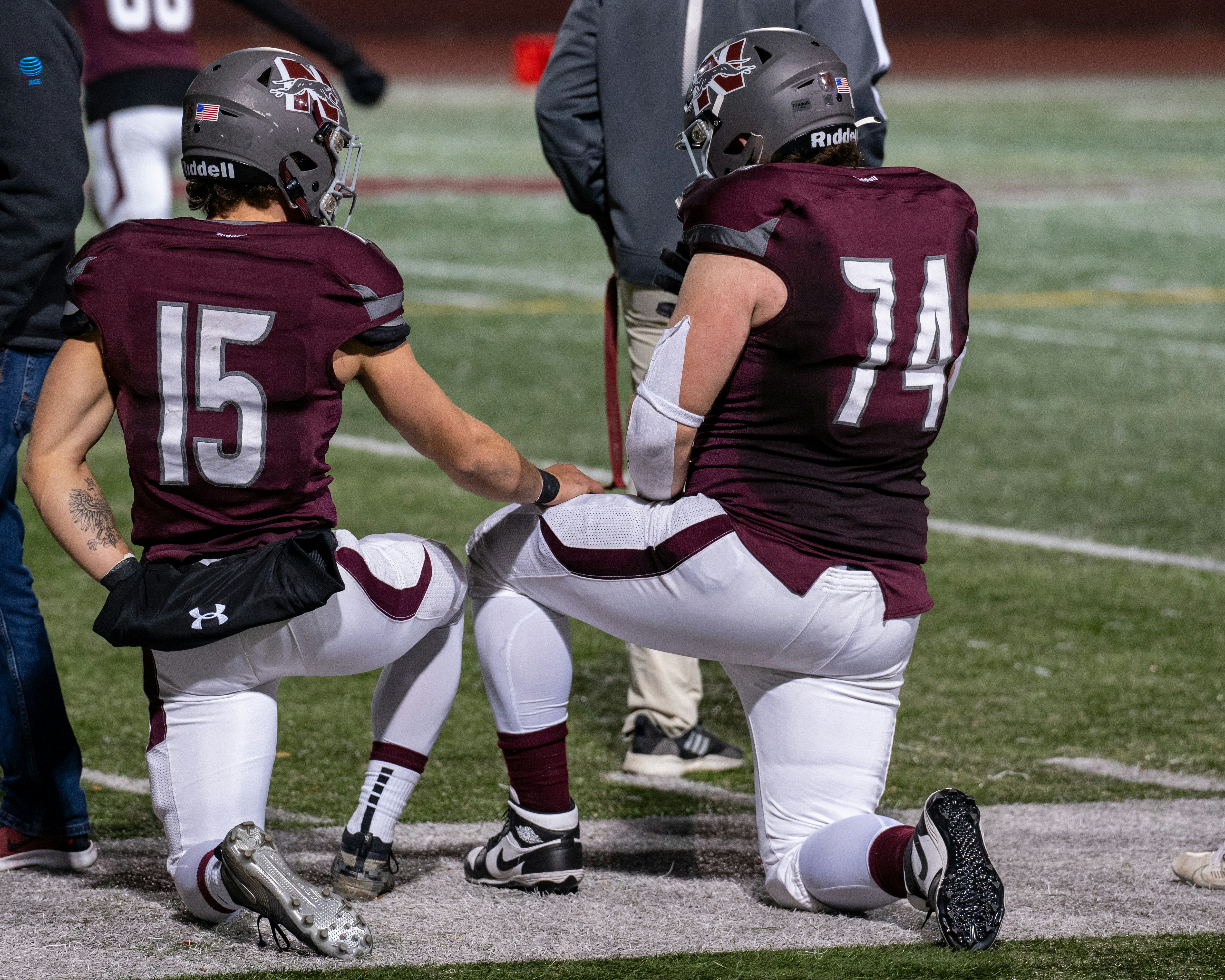 A group of young men sitting on top of a field