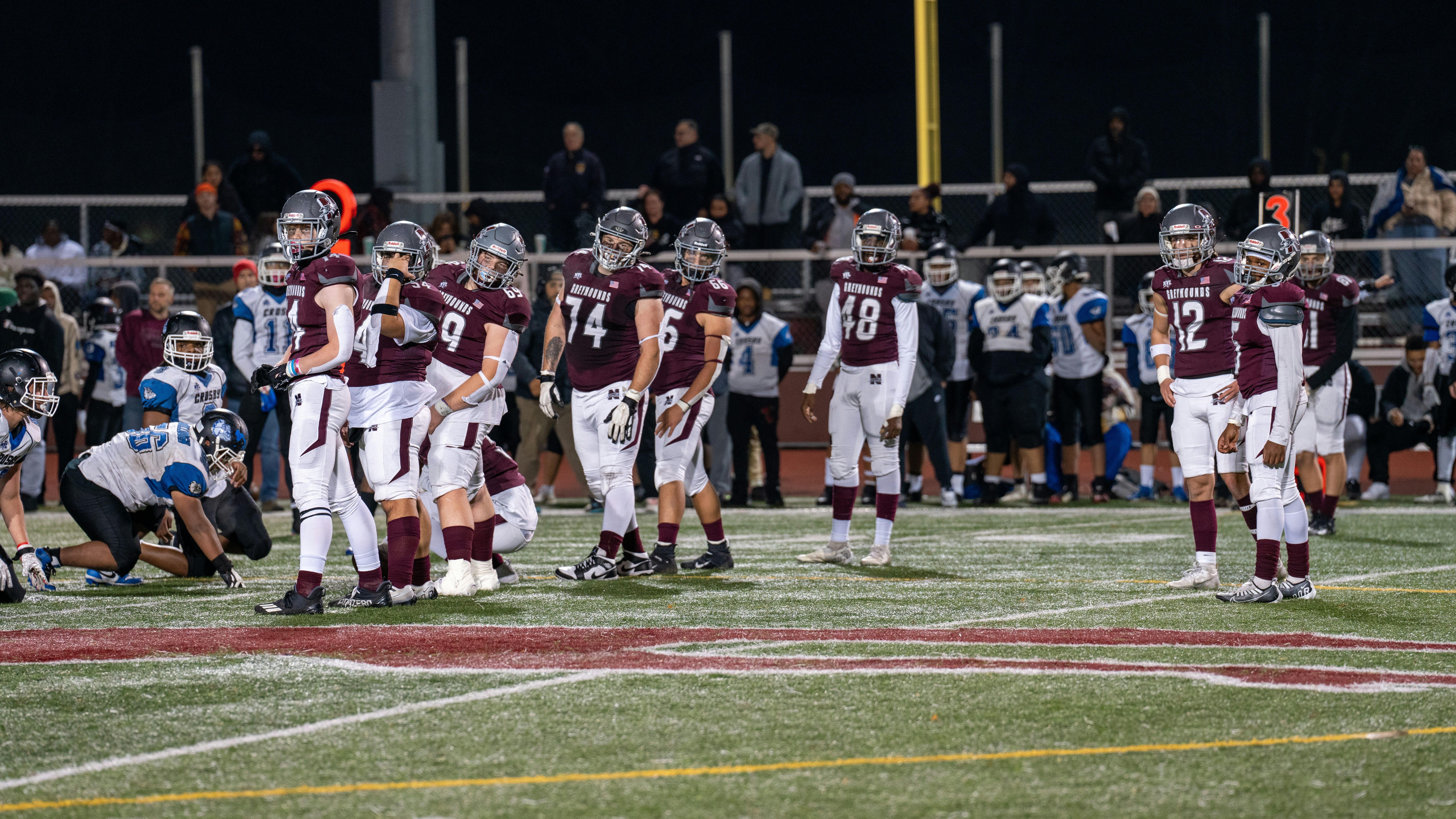 A group of football players standing on top of a field