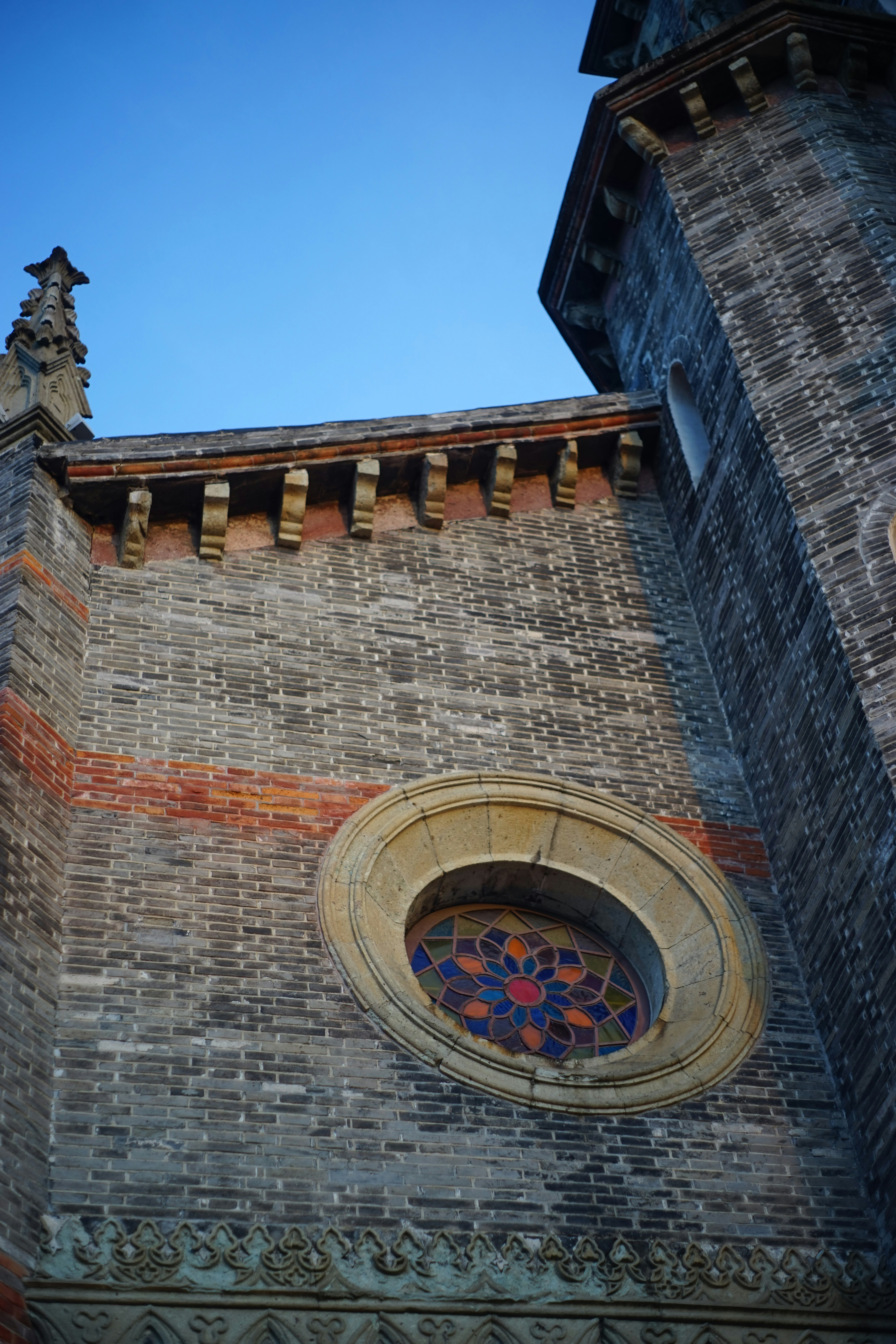 A tall brick building with a stained glass window