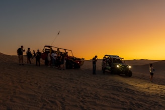 A group of people standing on top of a sandy beach