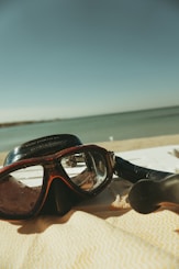 A pair of goggles sitting on top of a beach