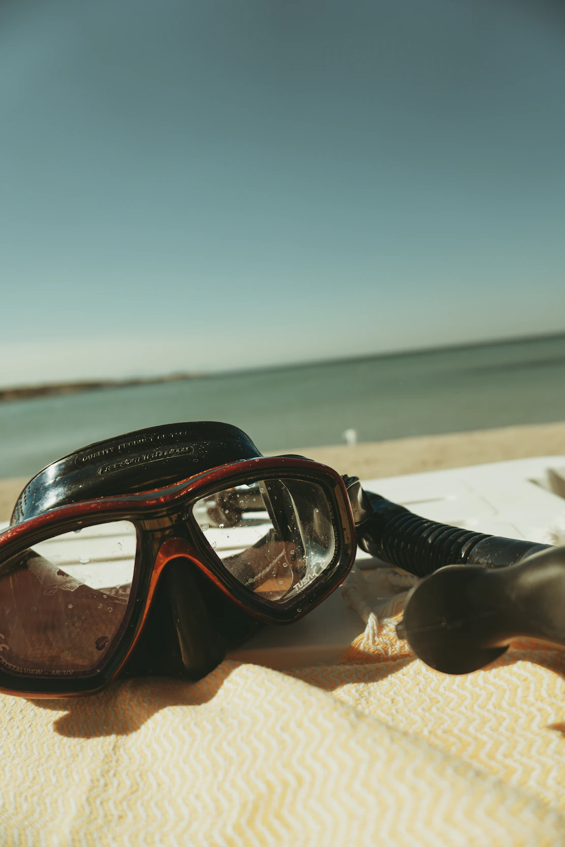 A pair of goggles sitting on top of a beach