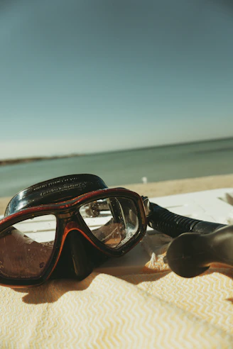 A pair of goggles sitting on top of a beach