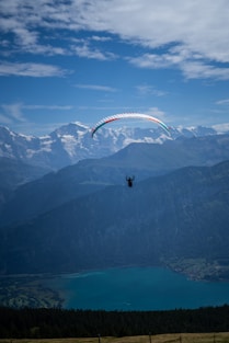 A paraglider is flying over a mountain range