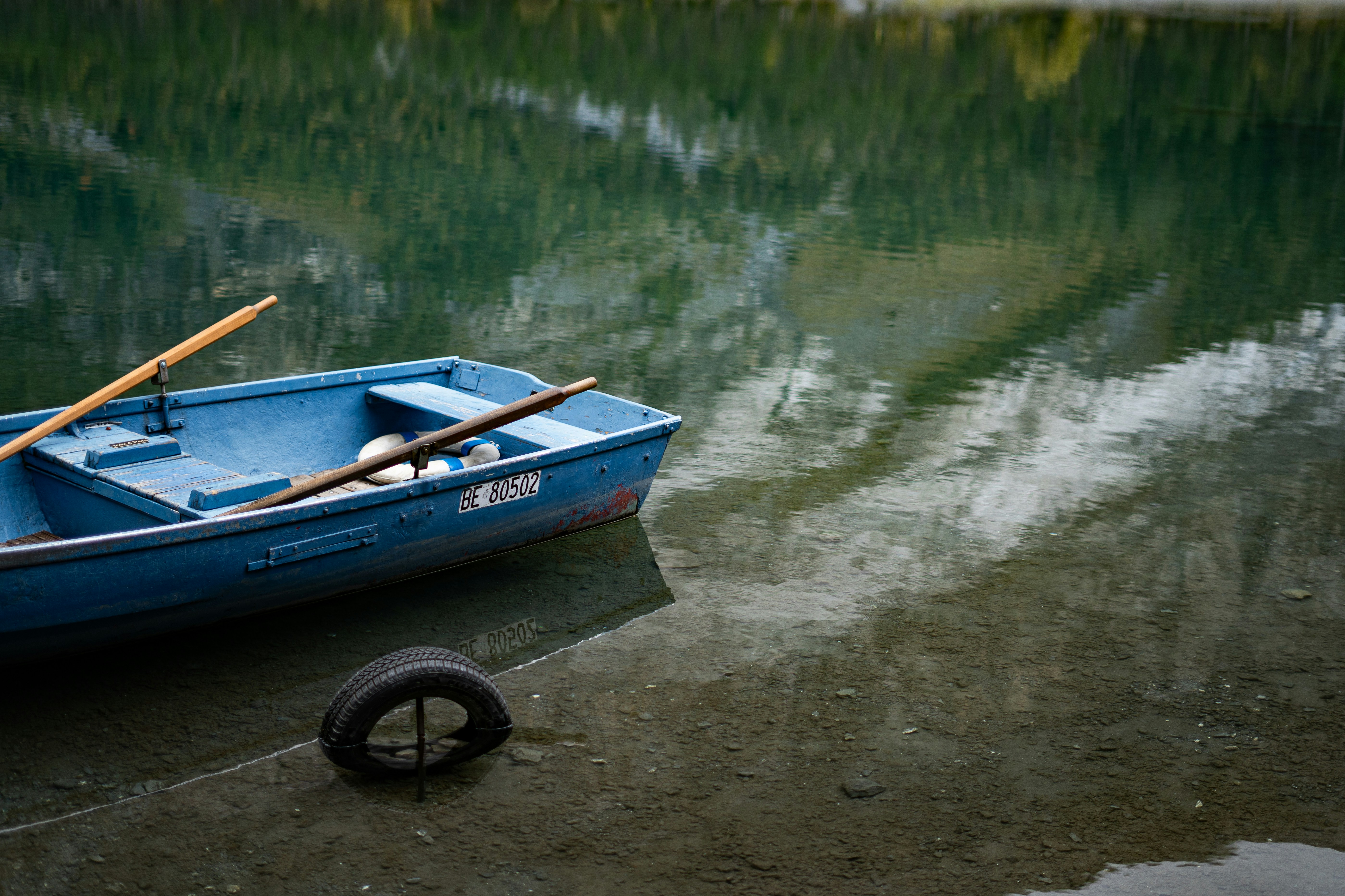 A small blue boat sitting on top of a lake