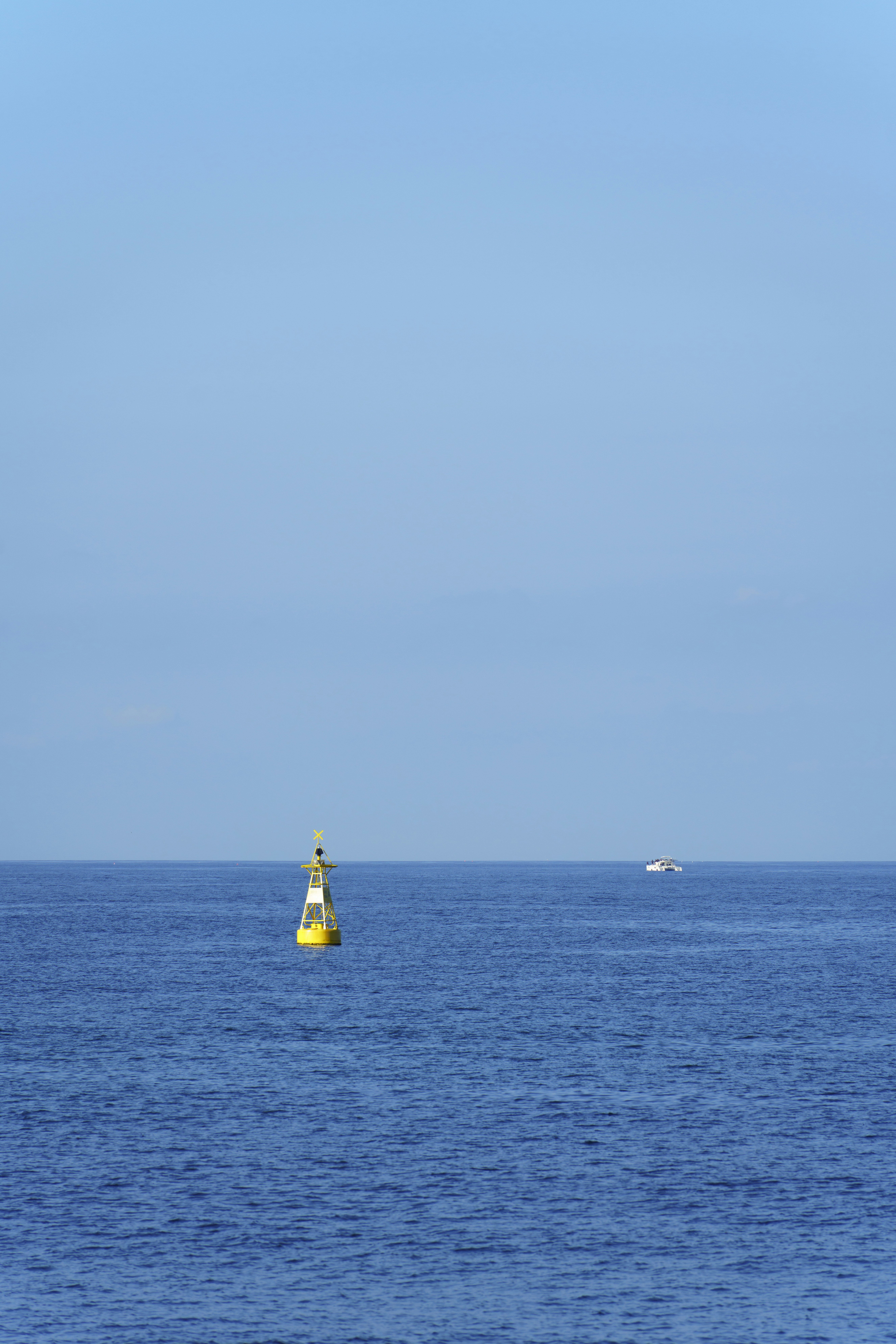 A yellow buoy floating in the middle of the ocean