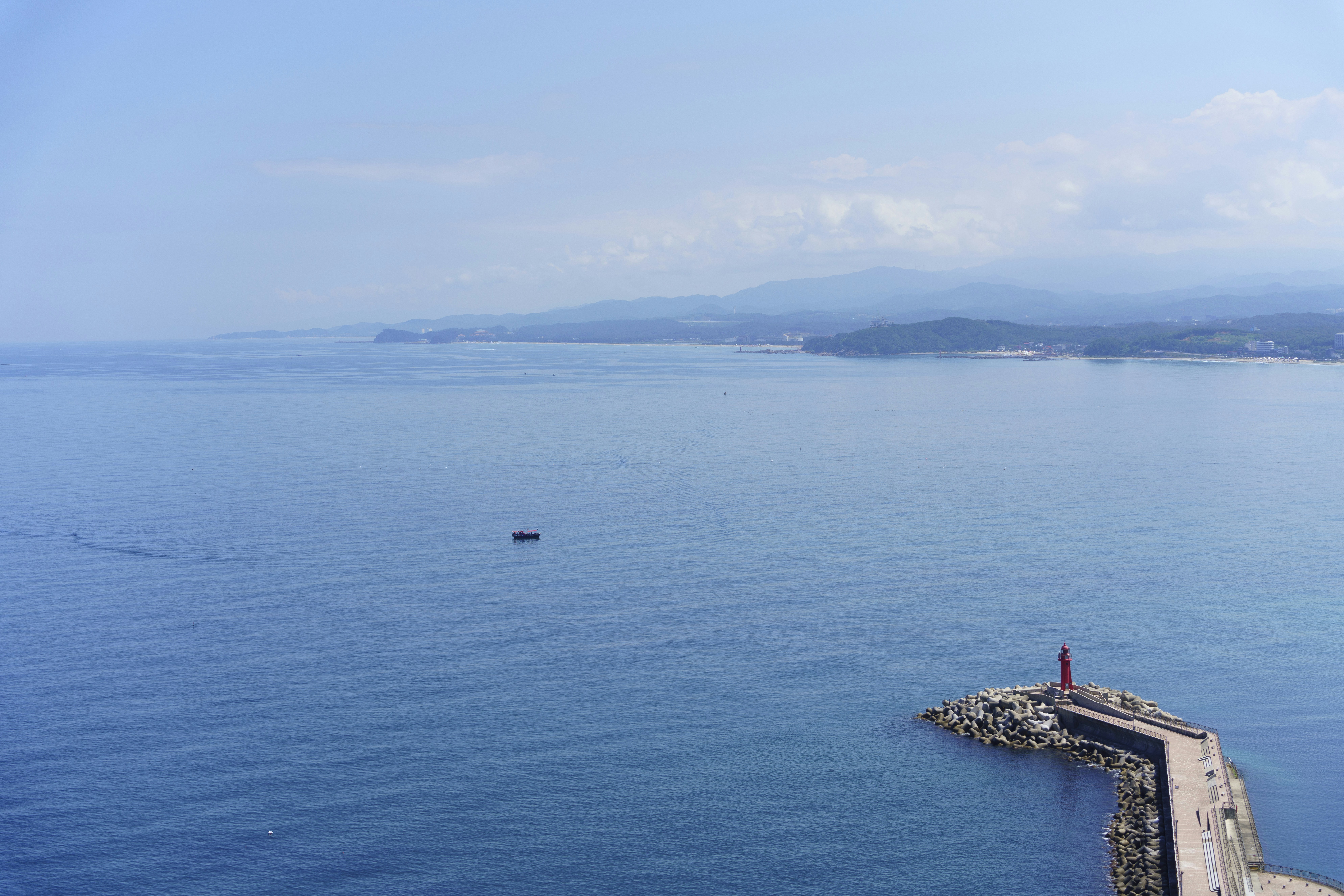A person standing on a pier in the middle of the ocean